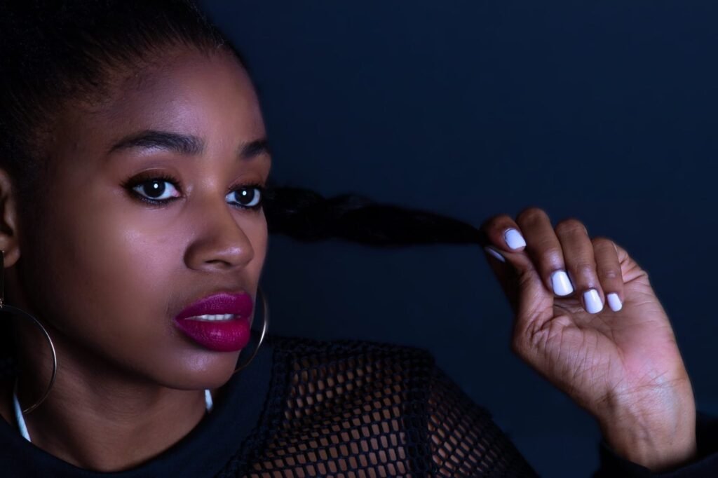 Close portrait of Lovett Love with deep berry lipstick in low navy light